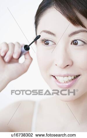 Stock Image - Woman applying mascara. Fotosearch