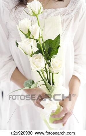 Woman holding a bouquet of white roses View Large Photo Image Stock Image - Woman holding a bouquet of white roses. Fotosearch