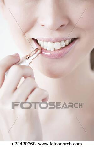 Stock Photo - Woman wearing a lipstick. Fotosearch