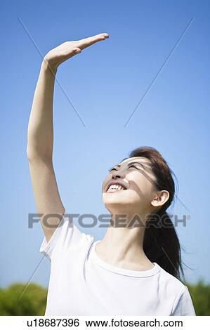 Stock Photograph - Woman with her hand raised. Fotosearch