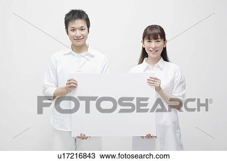 Young couple holding blank cardboard View Large Photo Image Stock Image - Young couple holding blank cardboard. Fotosearch