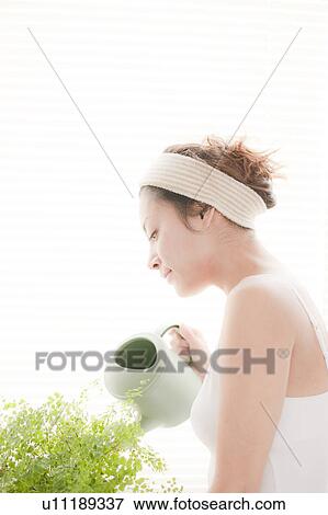 Young Woman Watering Houseplant View Large Photo Image Stock Photo - Young Woman Watering Houseplant. Fotosearch