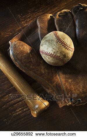 Stock Image - Antique baseball on baseball glove with bat. Fotosearch
