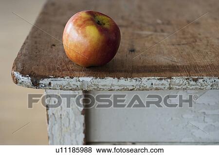 Apple on the egde of table View Large Photo Image Stock Photo - Apple on the egde of table. Fotosearch