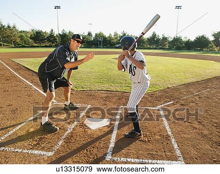 Baseball coach and boy (10-11) standing on baseball diamond View Large Photo Image Stock Photo - Baseball coach and boy (10-11) standing on baseball diamond. Fotosearch