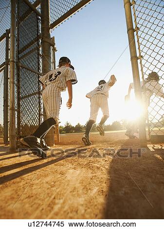Baseball players (10-11) entering baseball diamond View Large Photo Image Stock Photography - Baseball players (10-11) entering baseball diamond. Fotosearch