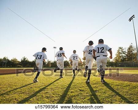 Baseball players (10-11) running on baseball diamond View Large Photo Image Picture - Baseball players (10-11) running on baseball diamond. Fotosearch