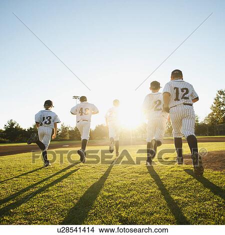 Baseball players (10-11) running on baseball diamond View Large Photo Image Picture - Baseball players (10-11) running on baseball diamond. Fotosearch