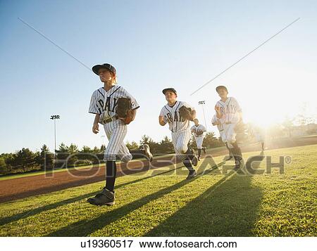 Baseball players (10-11) running on baseball diamond View Large Photo Image Stock Photo - Baseball players (10-11) running on baseball diamond. Fotosearch