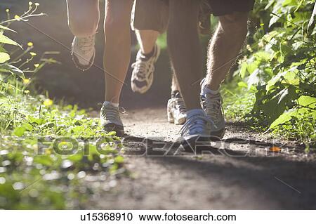 Stock Image - Canada, British Columbia, Fernie, Foot of three jogging people. Fotosearch