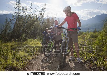 Stock Photo - Canada, British Columbia, Fernie, Group of four friends enjoying mountain biking. Fotosearch
