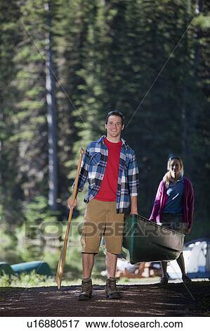 Canada, British Columbia, Fernie, Couple carrying canoe View Large Photo Image Stock Photo - Canada, British Columbia, Fernie, Couple carrying canoe. Fotosearch