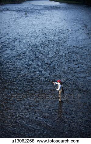 Canada, British Columbia, Fernie, Woman fly fishing in river View Large Photo Image Stock Photo - Canada, British Columbia, Fernie, Woman fly fishing in river. Fotosearch