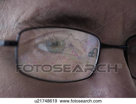 Stock Photo - Close-up of man's eye with graph reflecting in glasses. Fotosearch
