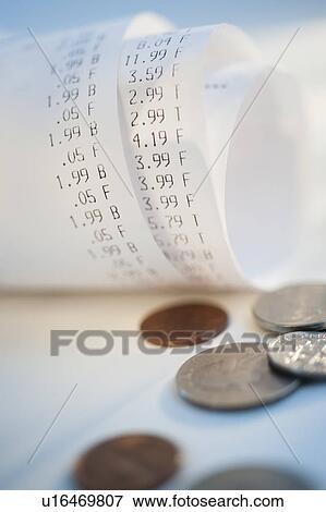 Stock Photo - Coins by rolled up receipts with prices. Fotosearch