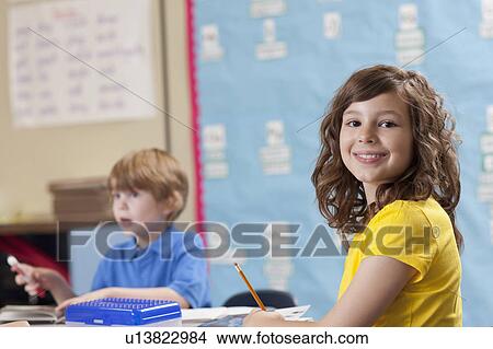 Girl (10-11) and boy (6-7) in classroom View Large Photo Image Picture - Girl (10-11) and boy (6-7) in classroom. Fotosearch