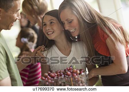 Stock Image - Girl (10 -11, ) with family during celebration event. Fotosearch