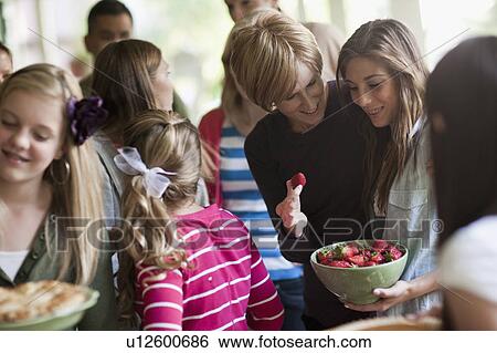 Stock Photograph - Girls (10-11, 14-15) with family during celebration event. Fotosearch