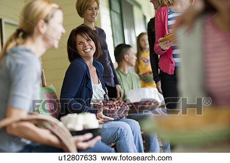 Stock Image - Girls (10-11, 14-15) with mother and family during celebration event. Fotosearch