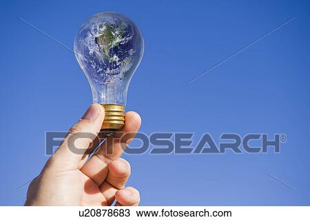 Stock Image - Hand holding lightbulb with globe. Fotosearch