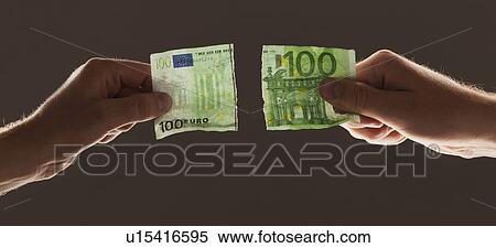 Stock Photography - Hands holding torn one hundred euro note. Fotosearch