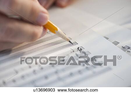 Man writing notes on sheet music View Large Photo Image Stock Image - Man writing notes on sheet music. Fotosearch