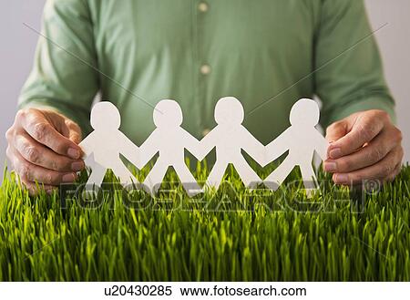 Stock Photography - Mid section of man holding paper chain over wheatgrass. Fotosearch