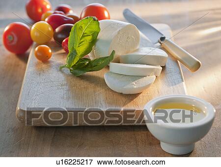 Mozarella and tomatoes on chopping board View Large Photo Image Stock Photo - Mozarella and tomatoes on chopping board. Fotosearch
