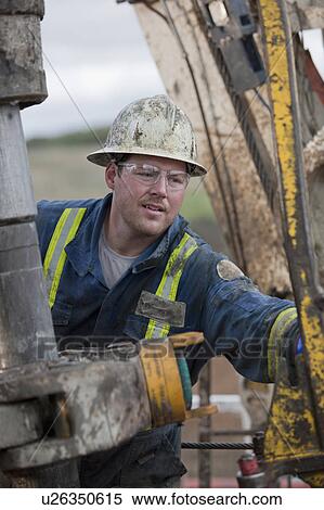 Stock Photography - Oil worker drilling for oil on rig. Fotosearch