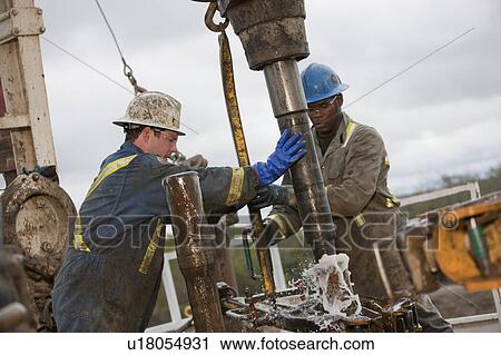 Stock Image - Oil workers drilling for oil on rig. Fotosearch