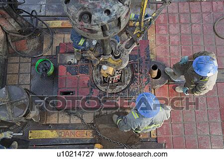 Stock Photo - Oil workers drilling for oil on rig. Fotosearch