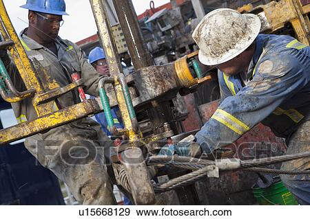 Oil workers drilling for oil on rig View Large Photo Image Stock Photo - Oil workers drilling for oil on rig. Fotosearch