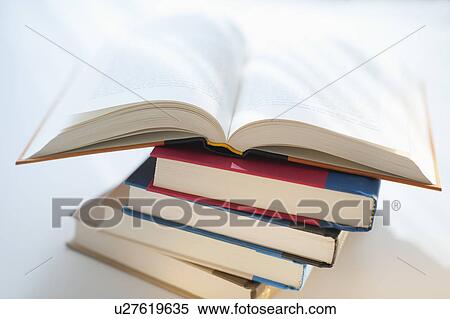 Stock Photography - Open book on stack. Fotosearch