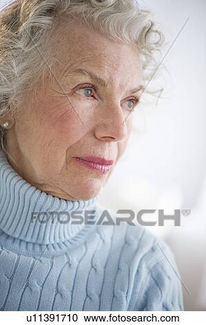 Stock Image - Pensive senior woman smiling. Fotosearch