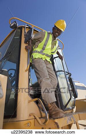 Stock Photo - Portrait of construction worker on mechanical digger. Fotosearch