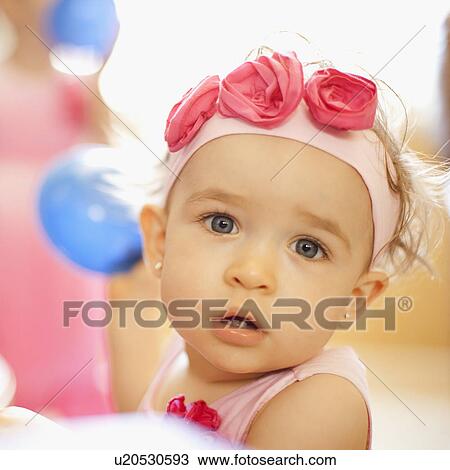 Stock Image - Portrait of girl (2-3) wearing headband with roses. Fotosearch