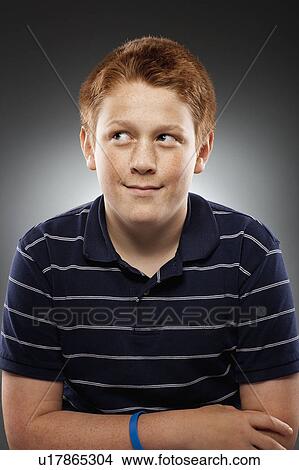 Picture - Portrait of redhead teenage boy (14-15) looking away, studio shot. Fotosearch