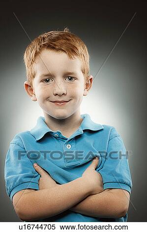 Portrait of smiling redhead boy (4-5) wearing blue polo shirt with arms crossed, studio shot View Large Photo Image Stock Photography - Portrait of smiling redhead boy (4-5) wearing blue polo shirt with arms crossed, studio shot. Fotosearch