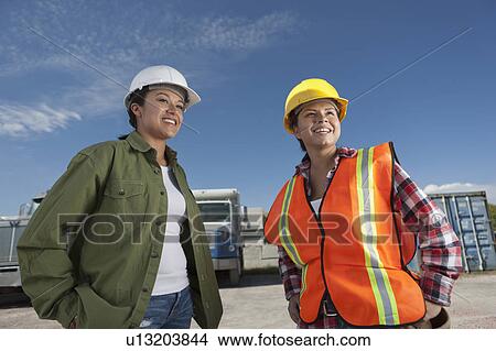 Picture - Portrait of two female construction workers on building site. Fotosearch