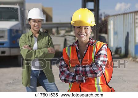 Stock Photography - Portrait of two female construction workers on building site. Fotosearch