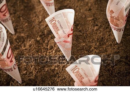 Stock Photograph - Rolled up ten euro notes stuck in ground. Fotosearch