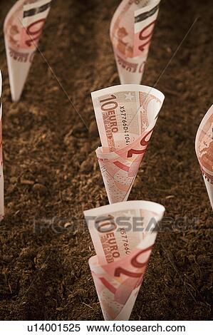 Stock Photography - Rolled up ten euro notes stuck in ground. Fotosearch