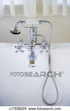 Stock Photo - Shower head connected to tap on bath. Fotosearch