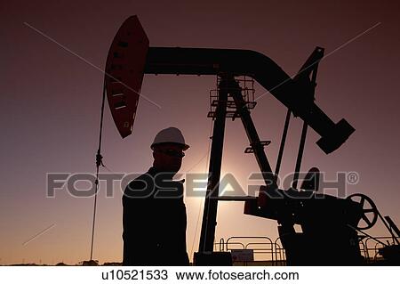 Silhouette of oil worker by pump jack on rig View Large Photo Image Stock Image - Silhouette of oil worker by pump jack on rig. Fotosearch