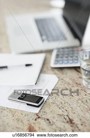 Picture - South Africa, Documents, laptop and mobile phone on desk, selective focus. Fotosearch