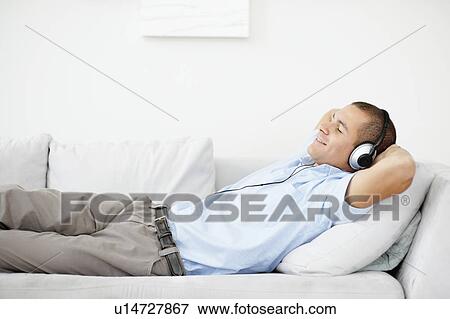 Stock Photo - South Africa, Man relaxing while listening music. Fotosearch