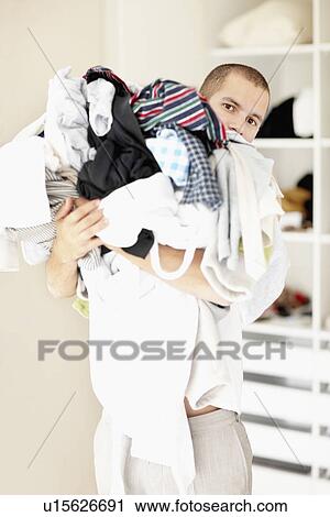 South Africa, Man standing with pile of laundry View Large Photo Image Stock Image - South Africa, Man standing with pile of laundry. Fotosearch