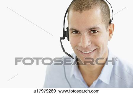 Stock Photo - South Africa, Portrait of smiling young man wearing headset, studio shot. Fotosearch
