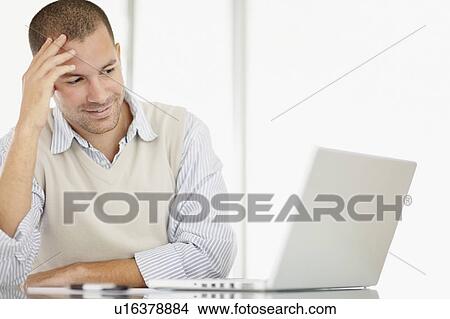 Picture - South Africa, Portrait of young man with laptop. Fotosearch