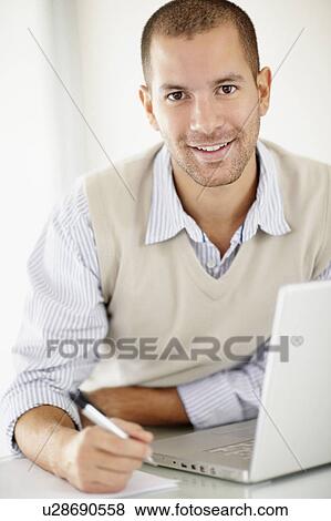 Stock Photo - South Africa, Portrait of young man with laptop. Fotosearch
